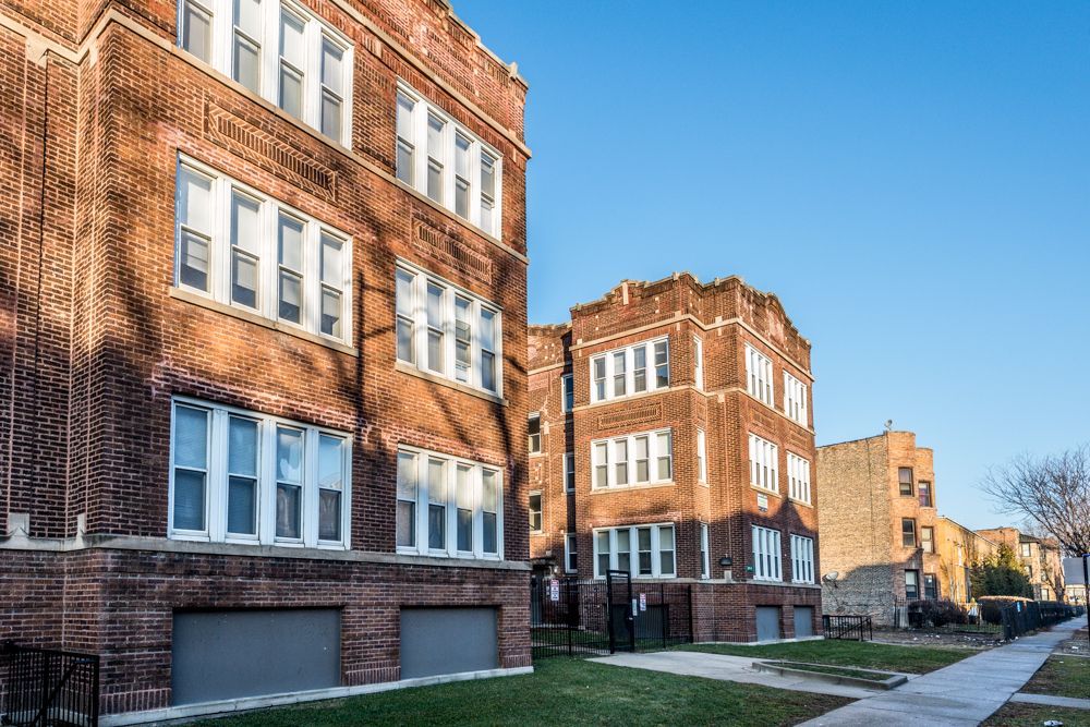 Brick apartment buildings under a clear blue sky.