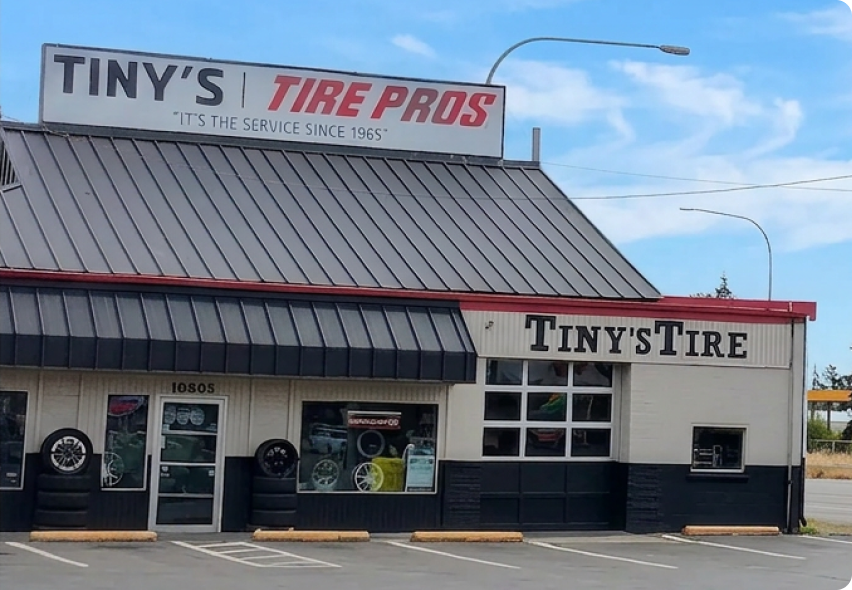 Tiny’s Tire Pros storefront with gray metal roof and large service signs. | Tiny's Tire Center