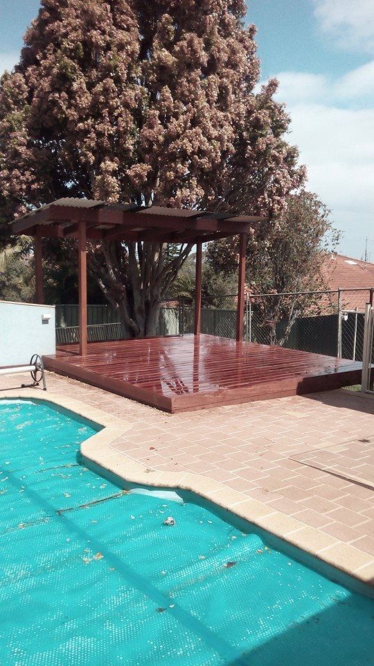 A Swimming Pool With a Wooden Deck — Seascapes Landscape Construction in Kendall, NSW