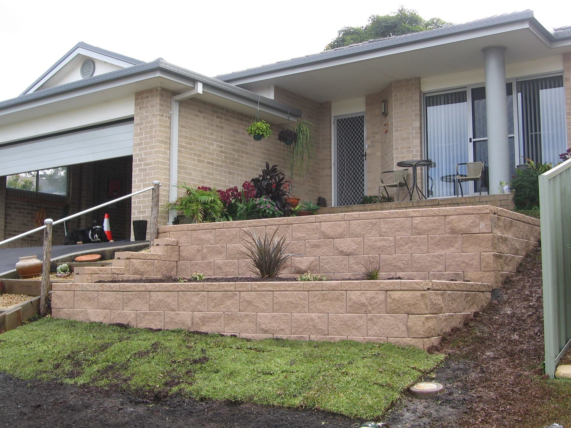 A House With a Brick Wall in Front of It — Seascapes Landscape Construction in Kendall, NSW