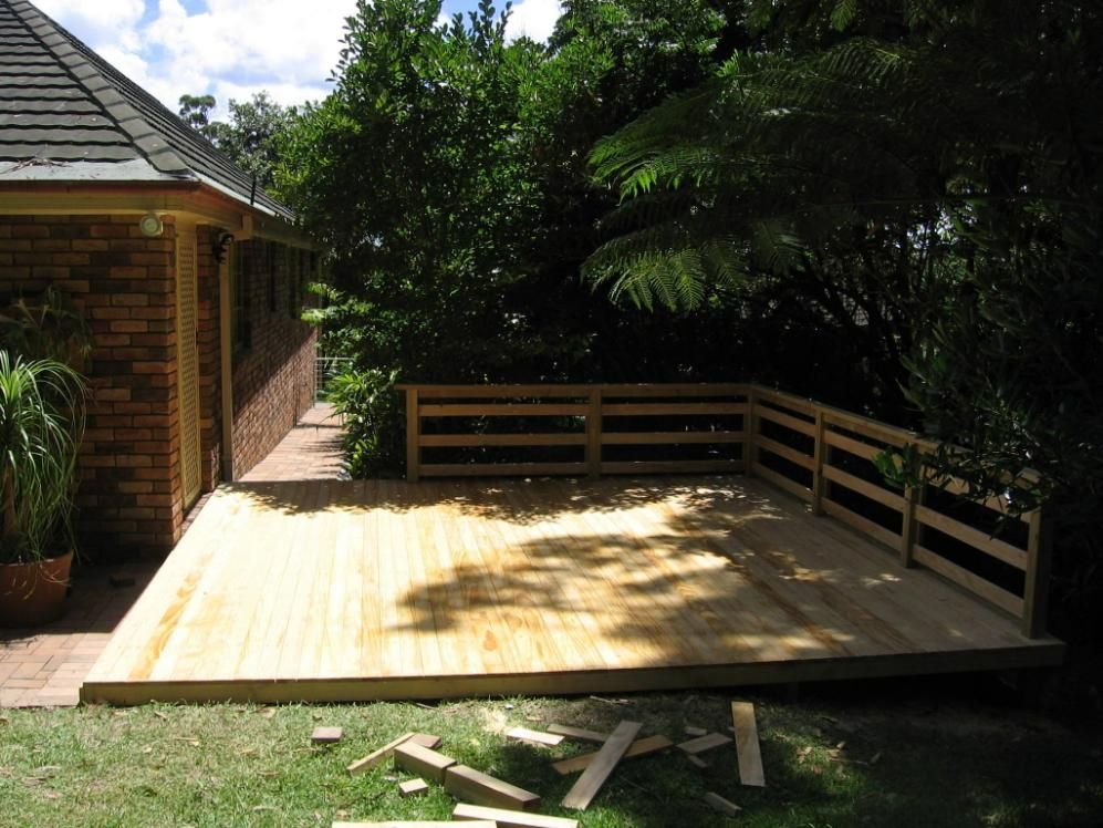 A Brick House With a Wooden Deck in Front of It — Seascapes Landscape Construction in Lake Cathie, NSW