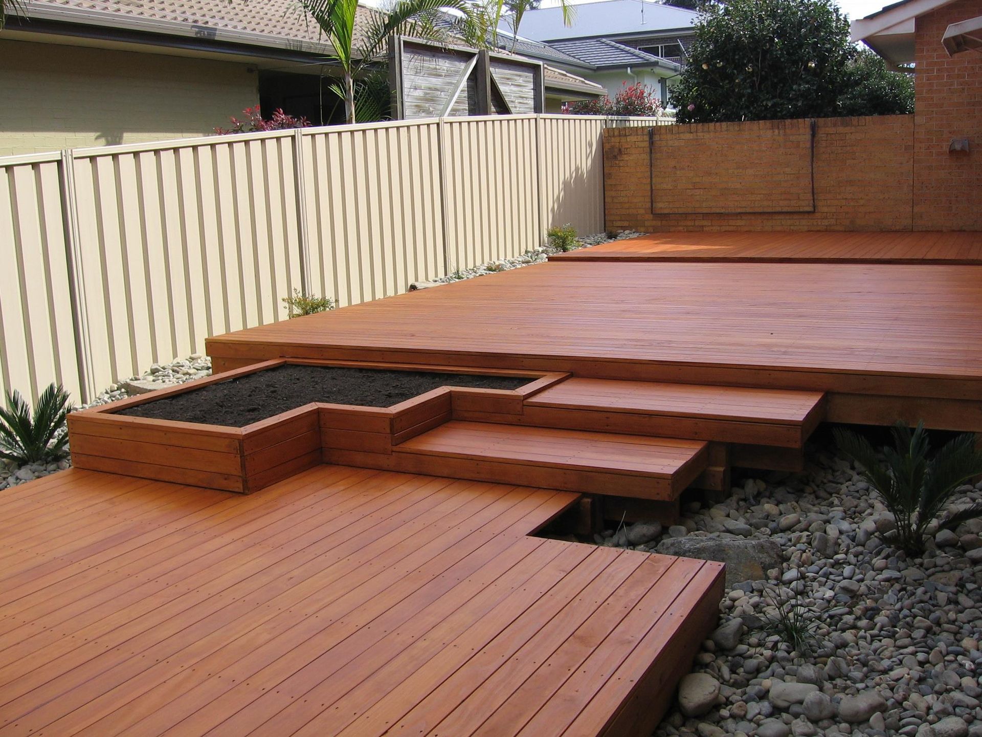 A Wooden Deck With Stairs Leading Up to It — Seascapes Landscape Construction in Kendall, NSW
