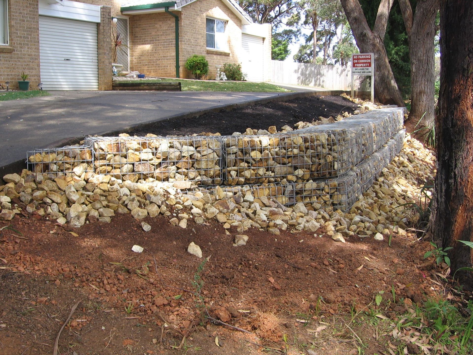 A Pile of Rocks Sits in Front of a House — Seascapes Landscape Construction in Kendall, NSW