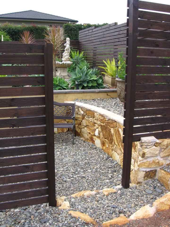 A Wooden Fence Surrounds a Gravel Area in a Garden — Seascapes Landscape Construction in Kendall, NSW