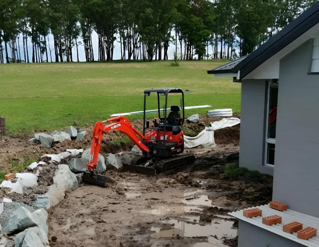 Orange Mini Excavator Working On The Garden — Landscaping Services in Kendall, NSW
