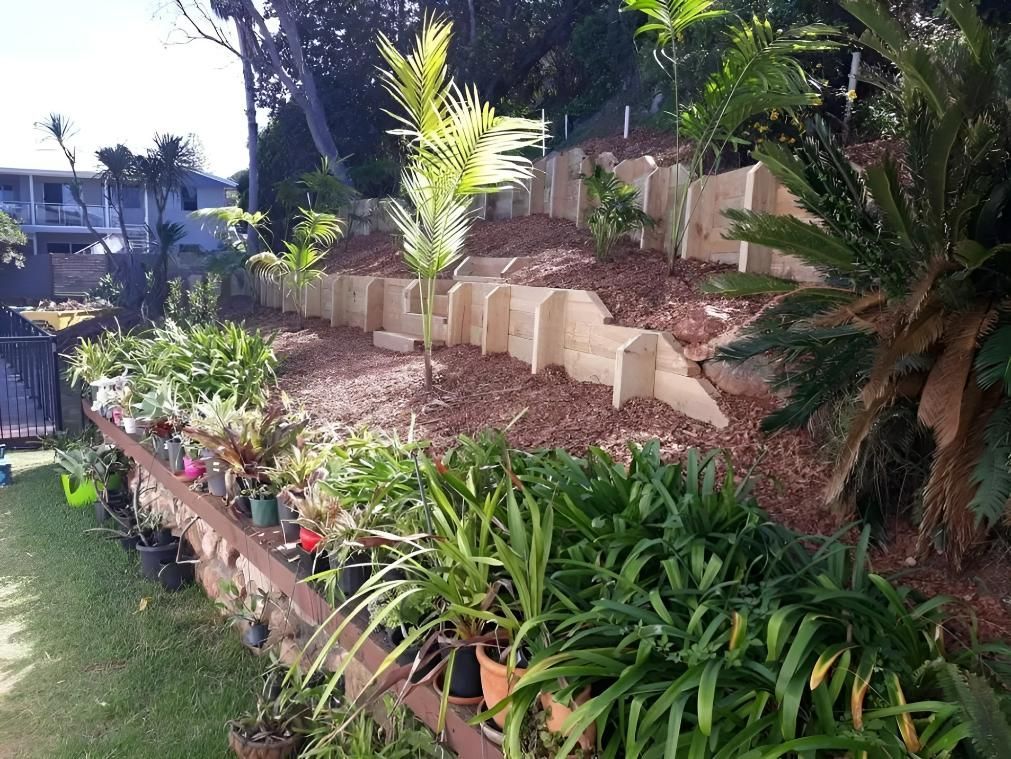 A Garden With Lots of Potted Plants on a Hillside — Seascapes Landscape Construction in Kendall, NSW