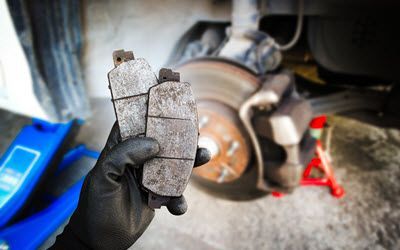 Audi Mechanic Holding Worn Brake Pads