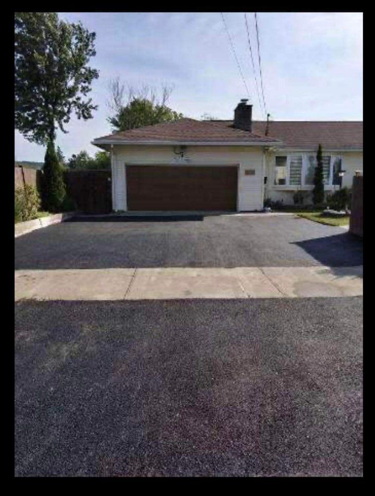Suburban house with a two-car garage and driveway, viewed from the street.