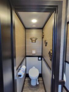 A small bathroom with a toilet and a crown on the wall