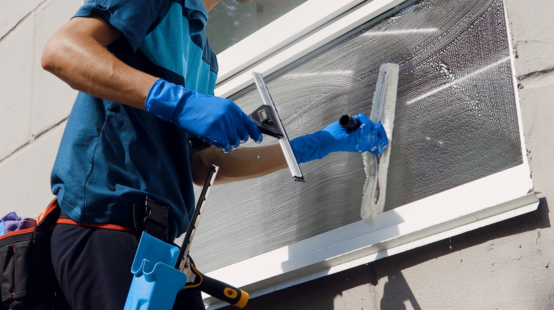 A man is cleaning a window with a squeegee.