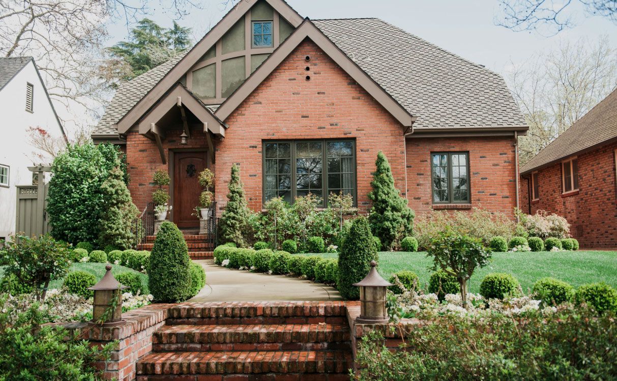 A brick house with stairs leading up to the front door