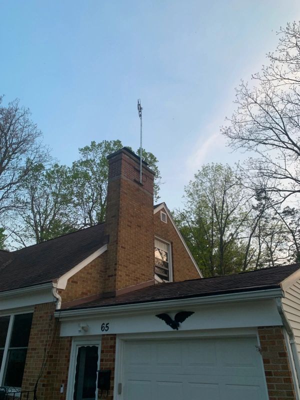 Brick house with American flag on chimney, garage, and blue sky.