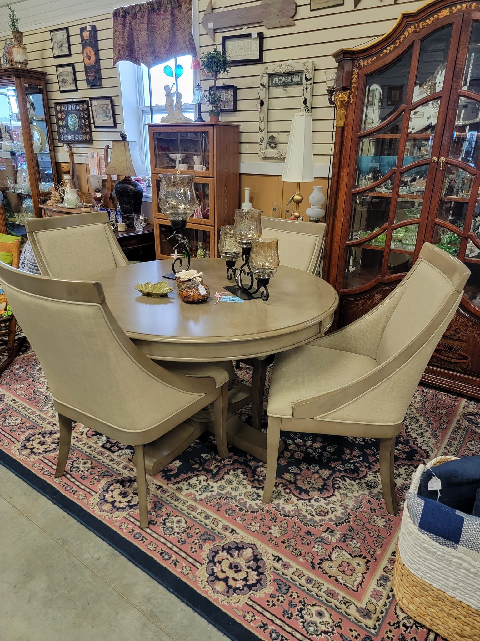 A dining room table and chairs are sitting on a rug in a room.