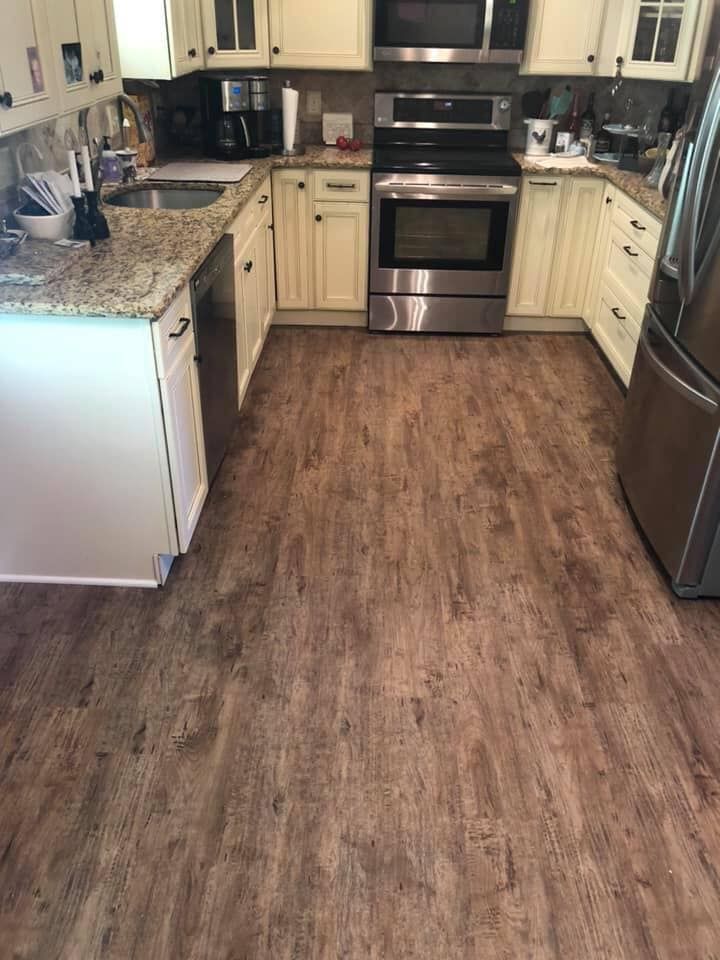 Kitchen with light cabinets, granite counters, stainless steel appliances, and wood-look flooring.