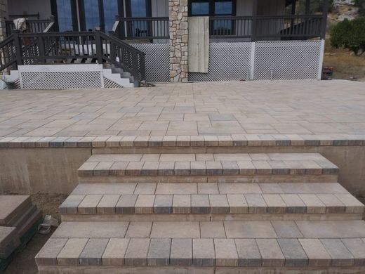 A concrete walkway with a large rock in the background