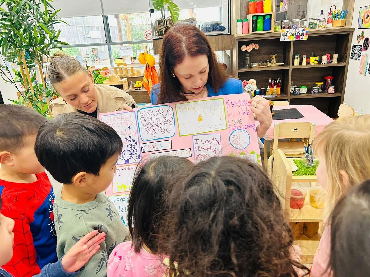 Teacher showing colorful cards to a small group of children in a classroom