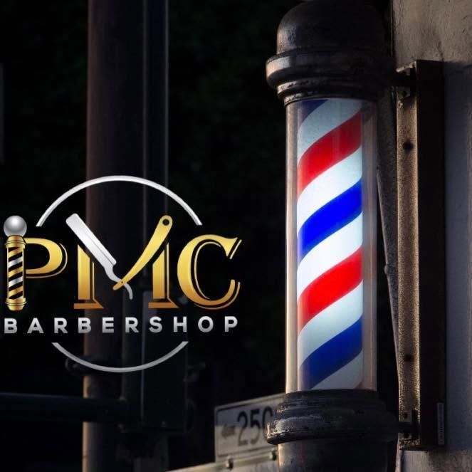 Classic barber pole with red, white, and blue stripes beside a PVM Barbershop sign