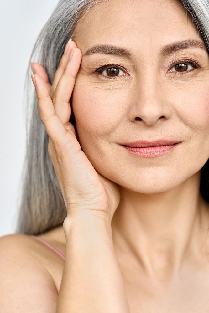 A close up of a woman 's face with her hand on her face.