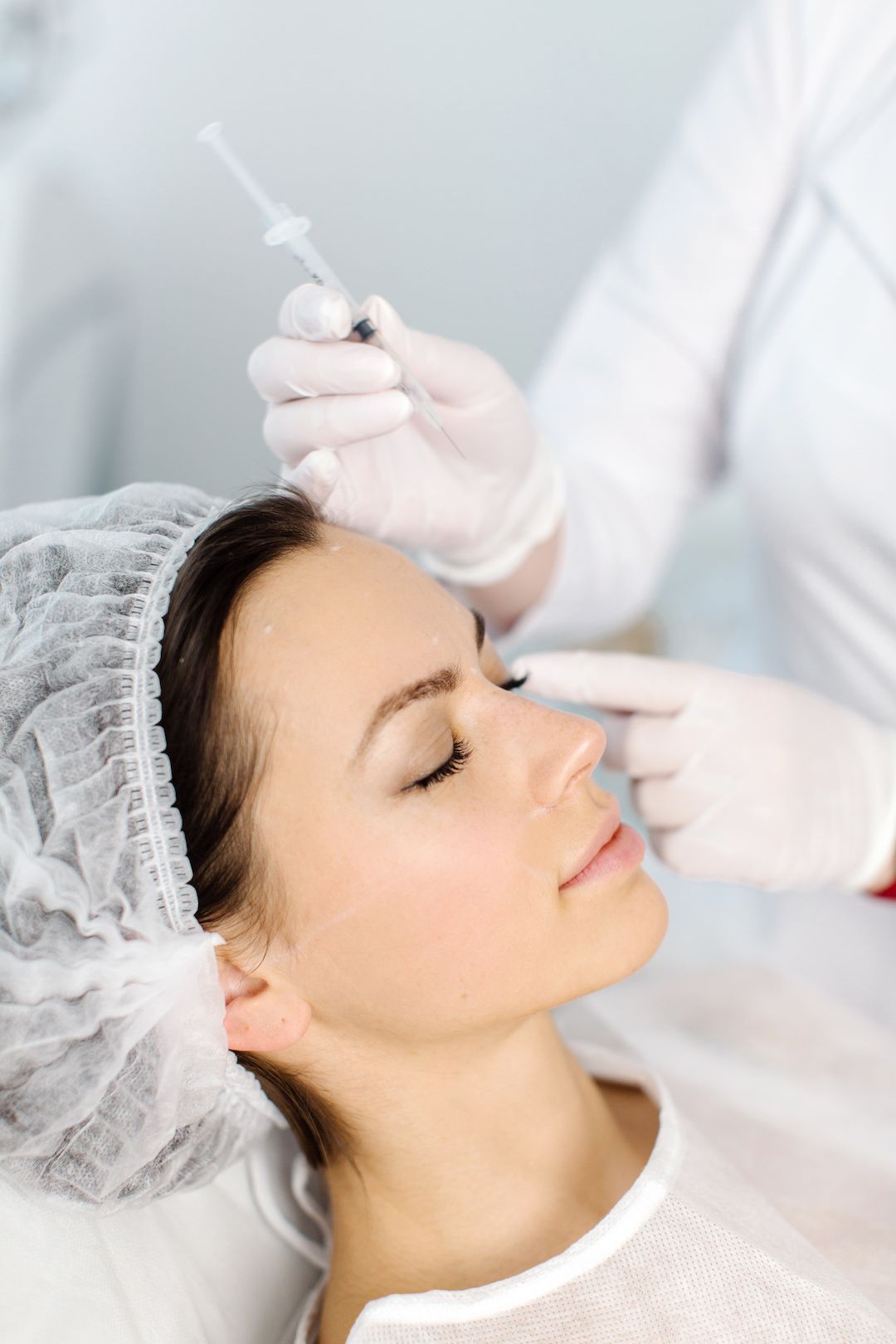 A woman is getting a botox injection in her face.