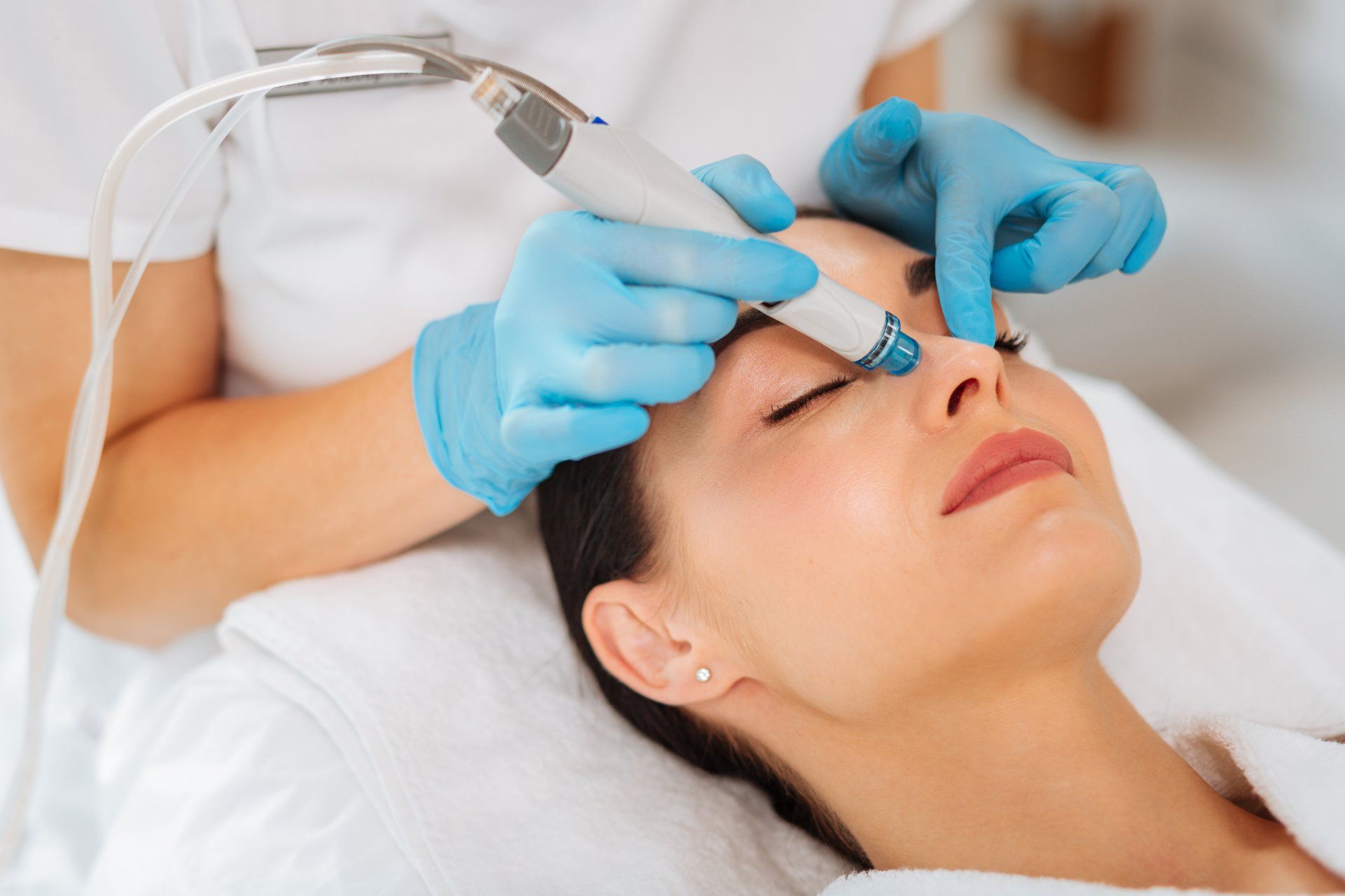 A woman is getting a facial treatment at a beauty salon.