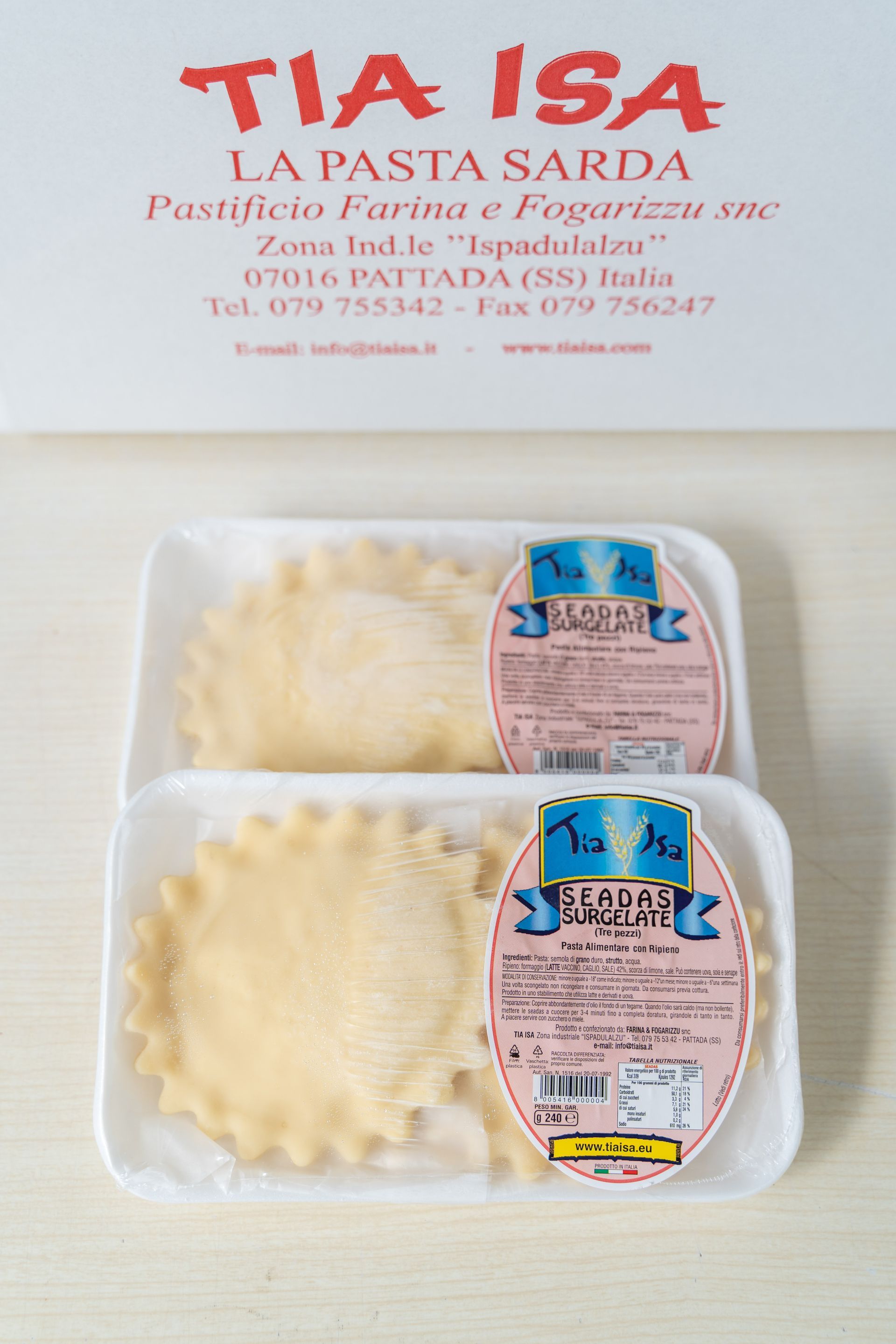 Frutti di mare surgelati confezionati in una vaschetta bianca con etichetta blu e logo giallo a forma di pesce.