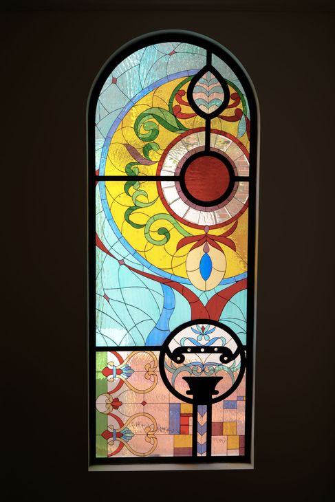 Vitral abstracto y colorido con motivos circulares y florales.