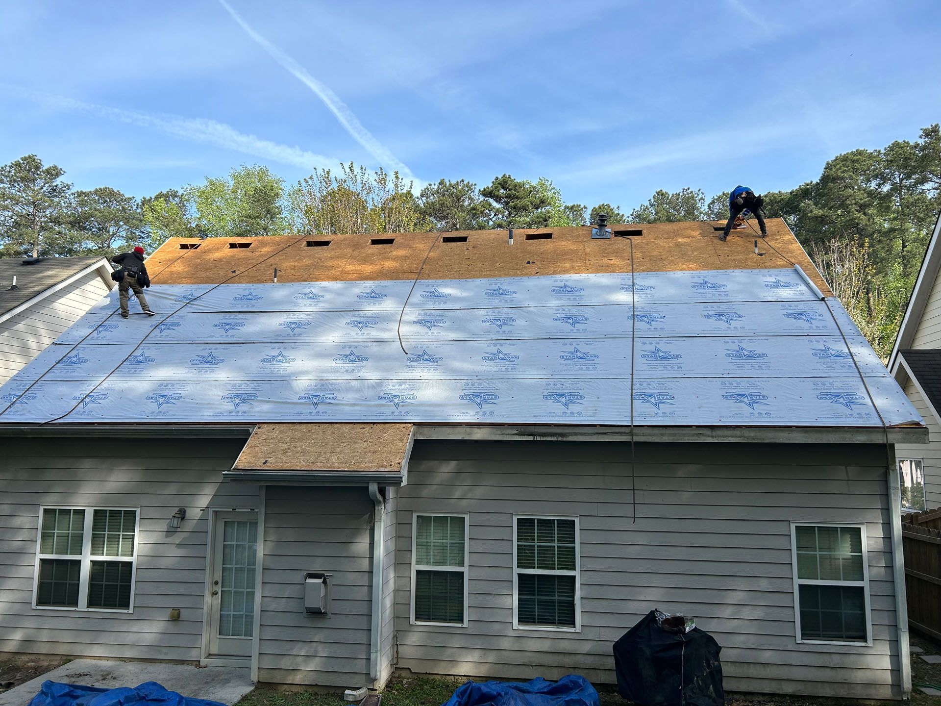 A man is working on the roof of a house.