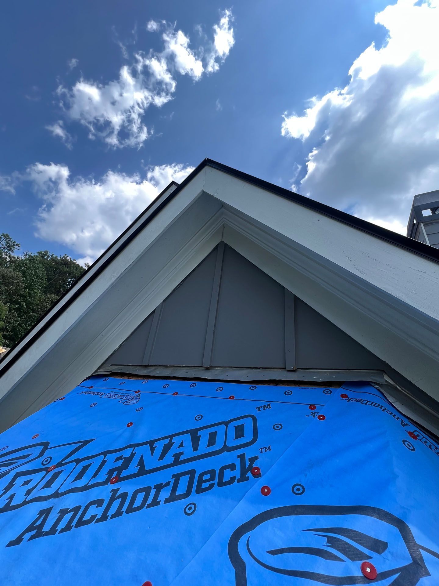 A blue tarp is covering the roof of a house.