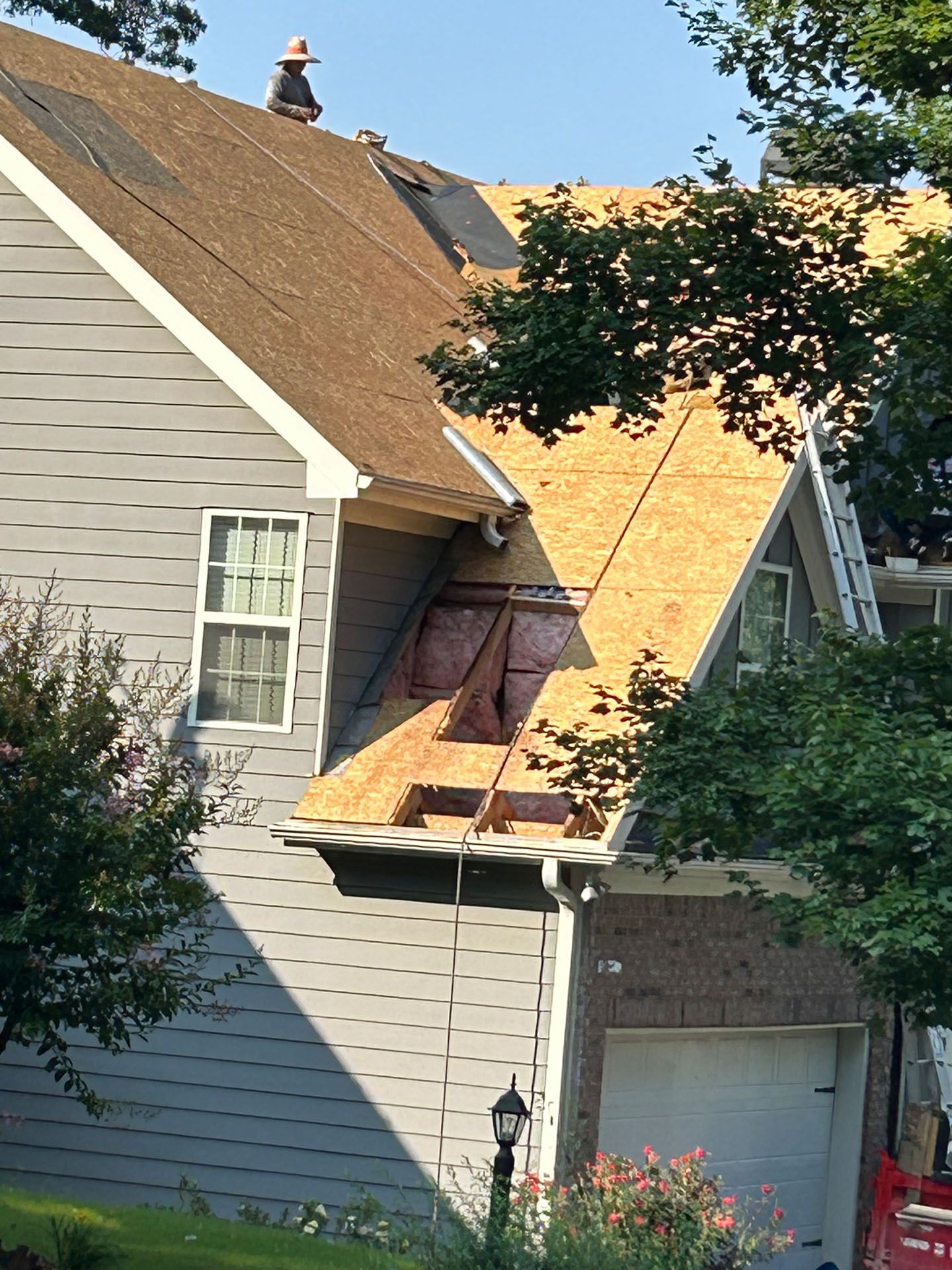 A man is working on the roof of a house