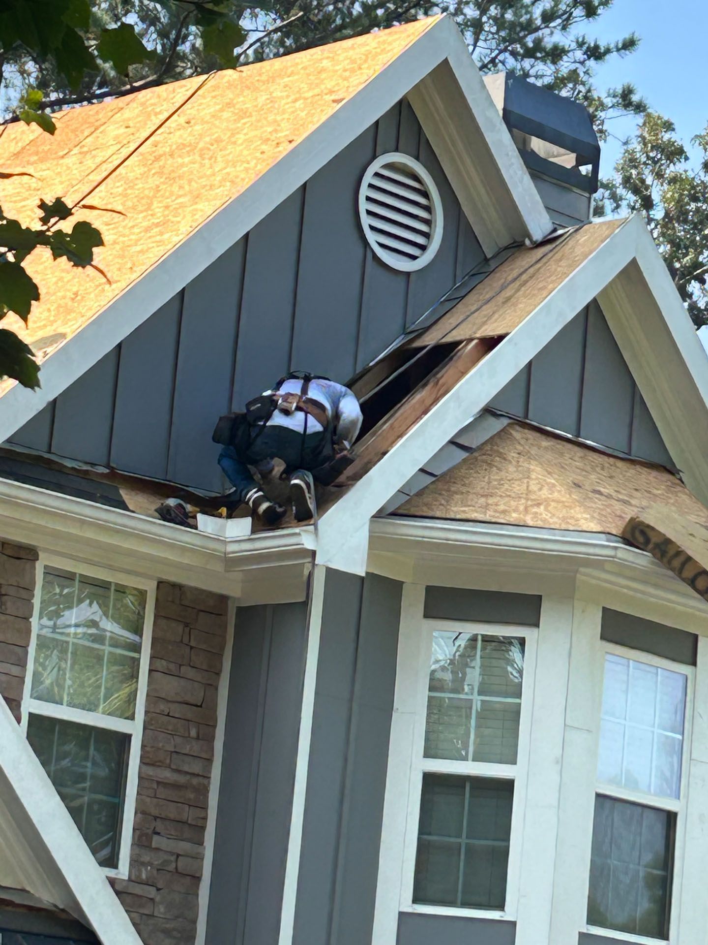 A man is working on the roof of a house.