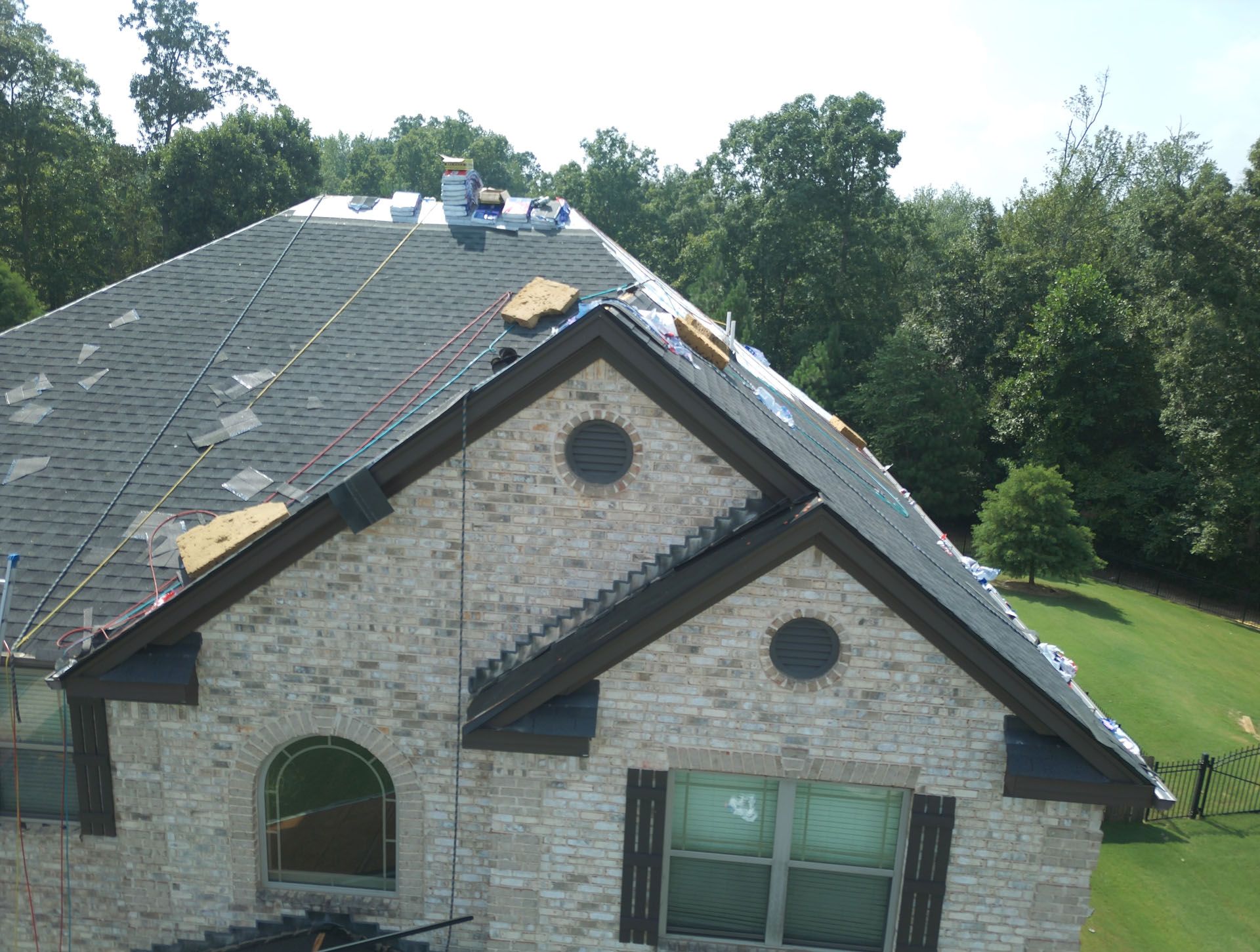 A brick house with a roof that is being installed