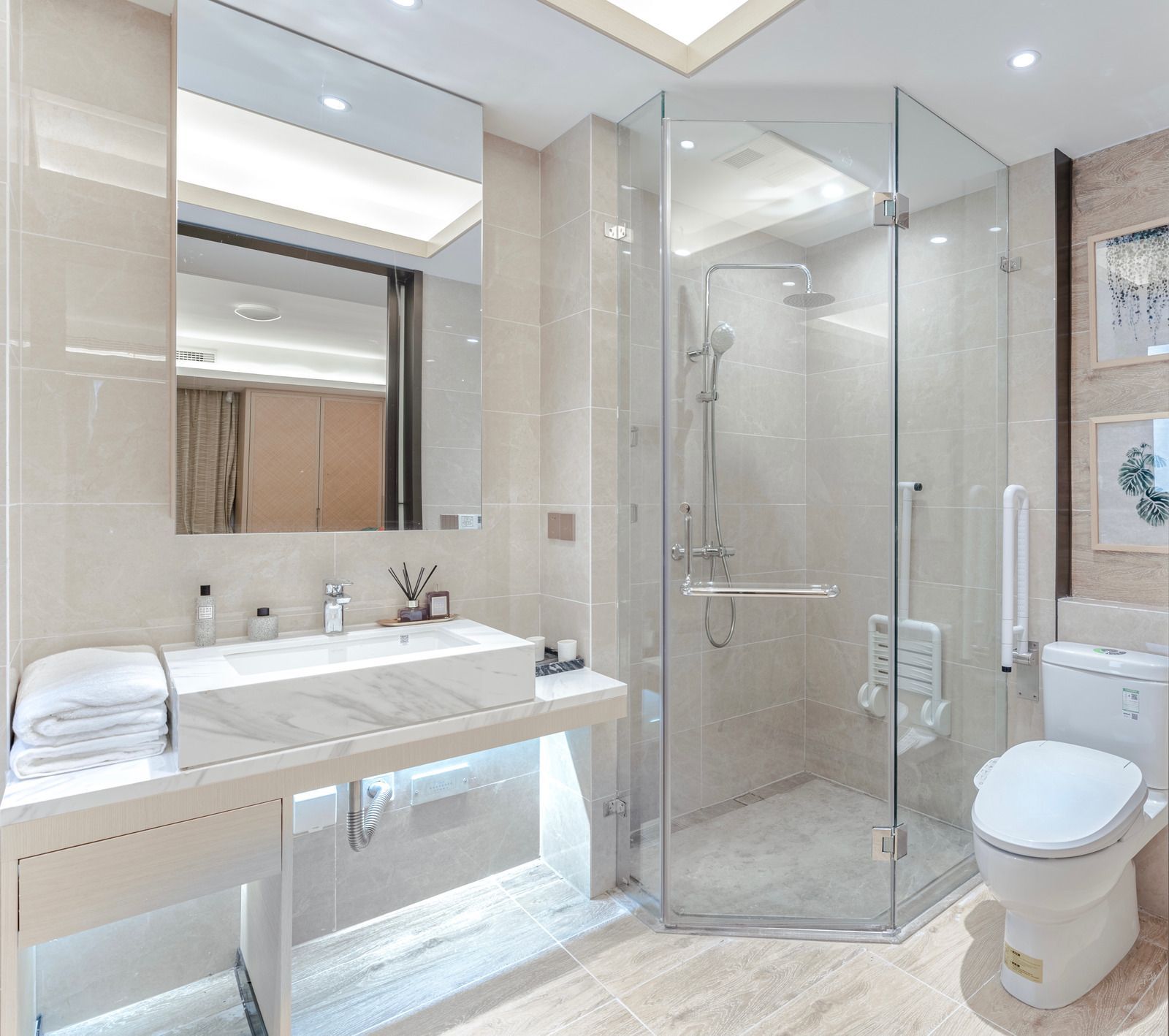 A bathroom with a toilet , sink , shower and mirror.