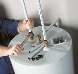 A man is fixing a water heater with a wrench.