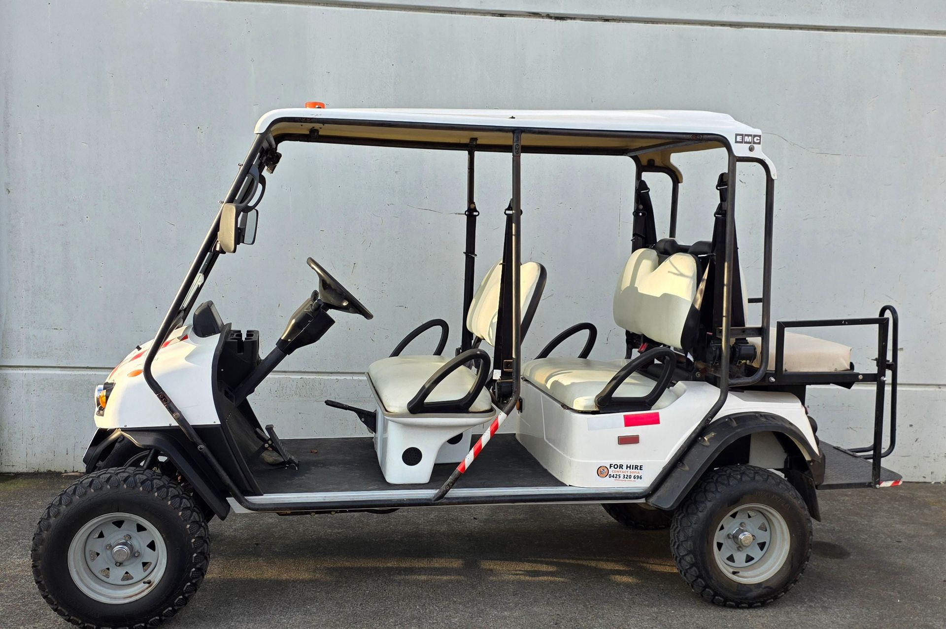 White golf cart with black frame and beige seats, parked in front of a gray wall — Lift It Equipment in Central Coast Region, NSW