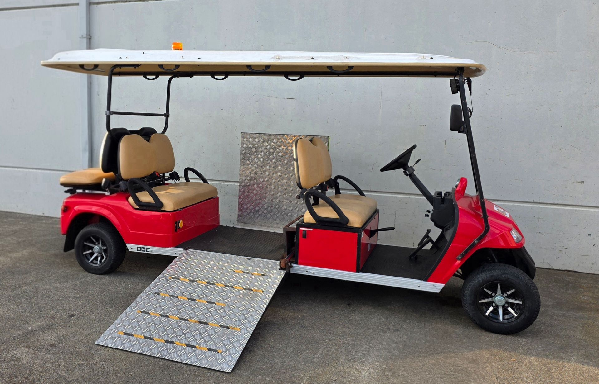 Red and black golf cart with wheelchair ramp and raised roof parked against a gray wall — Lift It Equipment in Central Coast Region, NSW