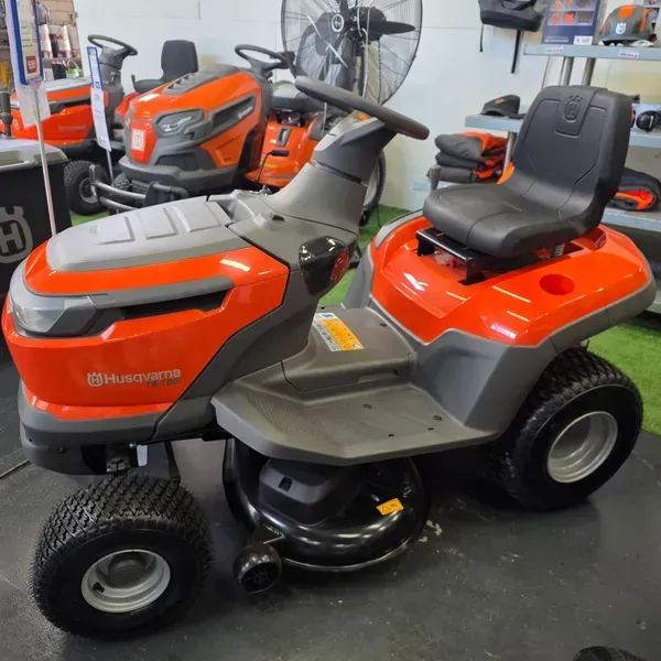 Orange Husqvarna Riding Lawn Mower in a Garage — Lift It Equipment in Tuggerah, NSW