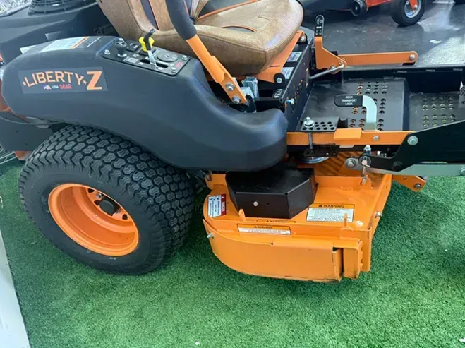 Orange and Black Liberty Z Lawn Mower Parked on Grass — Lift It Equipment in Tuggerah, NSW