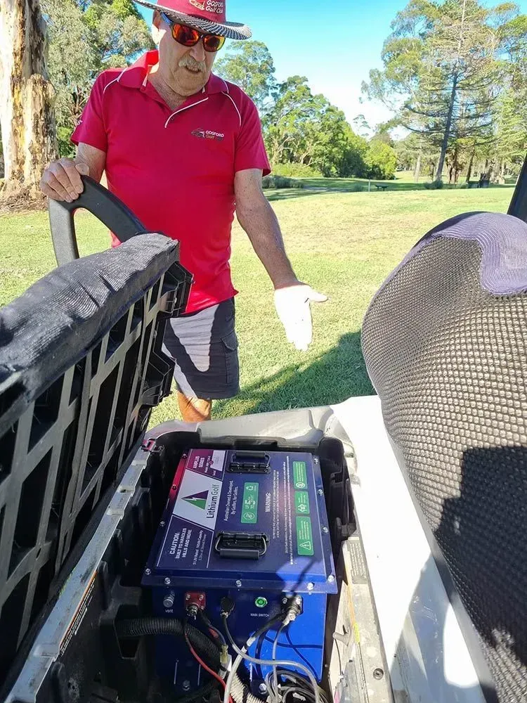 Person in Red Shirt and Hat Inspecting a Battery Unit — Lift It Equipment in Summerland Point, NSW