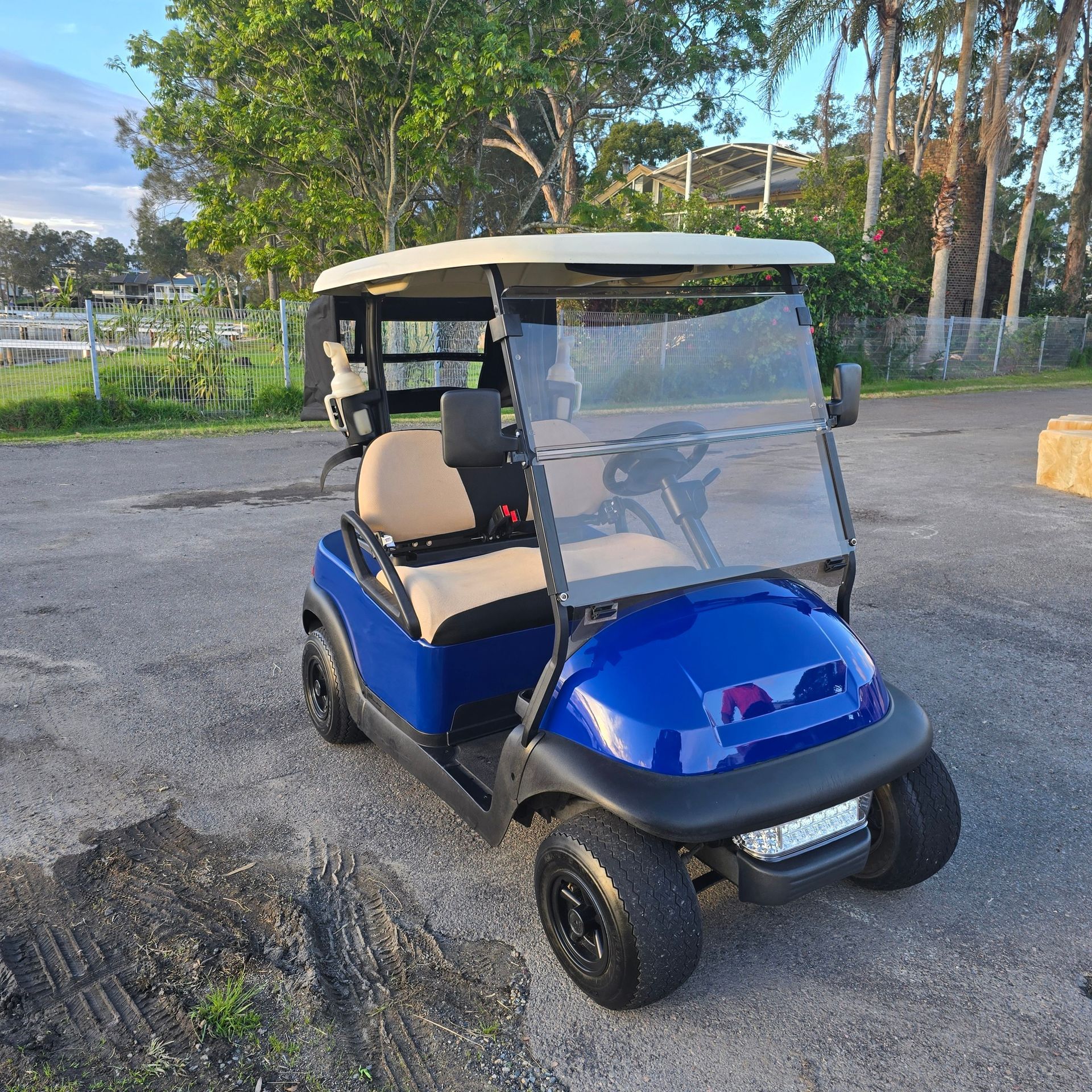Blue Golf Cart Parked on Gravel, With Tan Seats and Clear Windshield — Lift It Equipment in Sydney, NSW