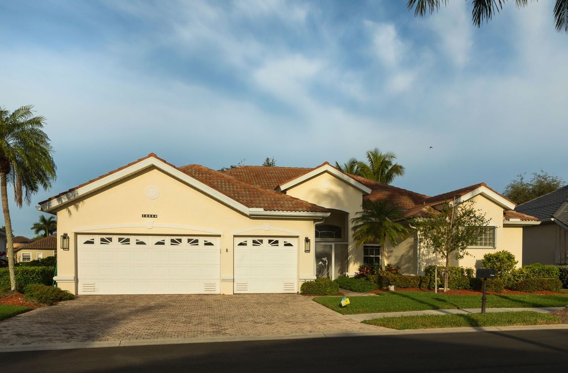 A House With Two White Garage Doors and a Red Tile Roof