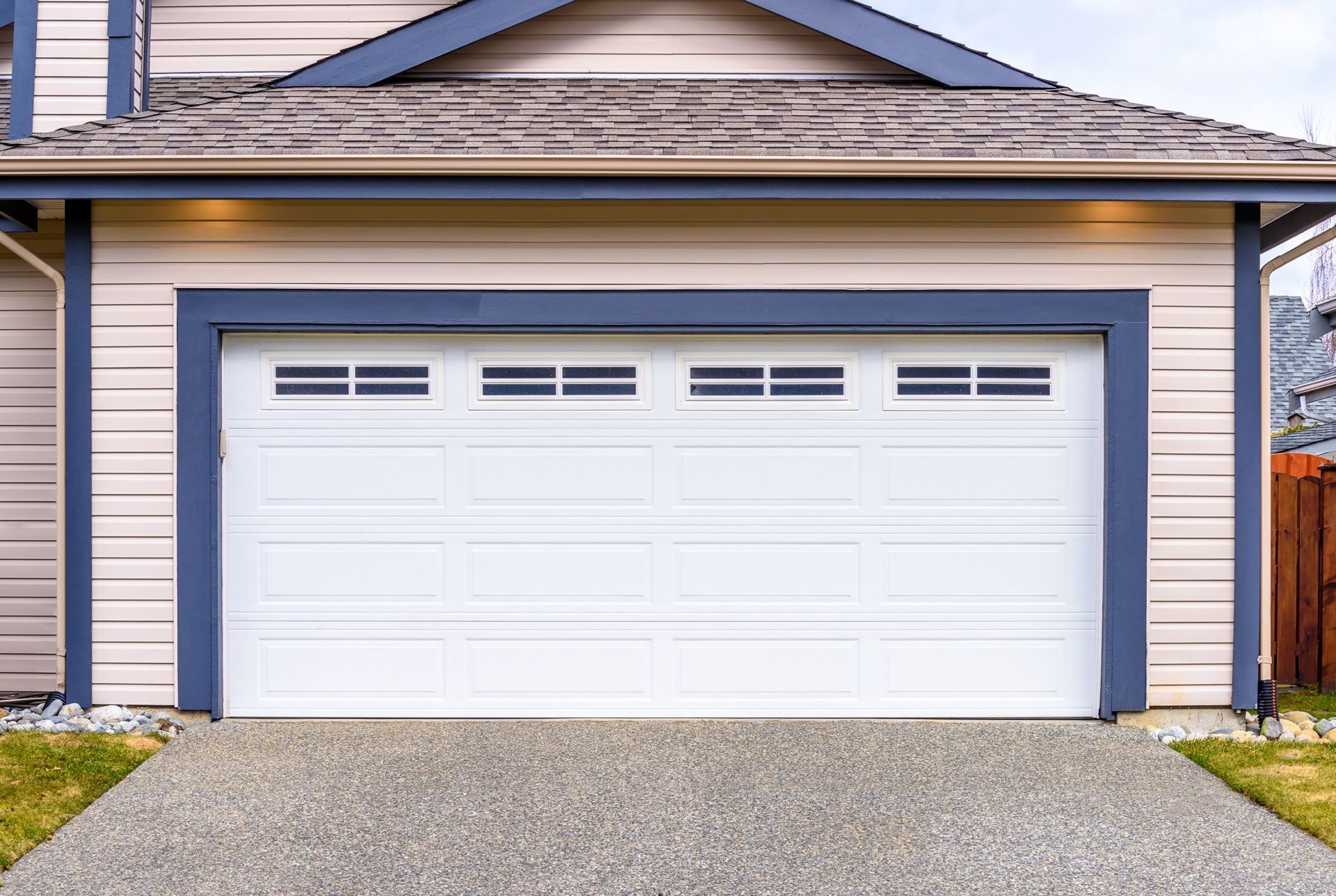 A White Garage Door is Sitting in Front of a House