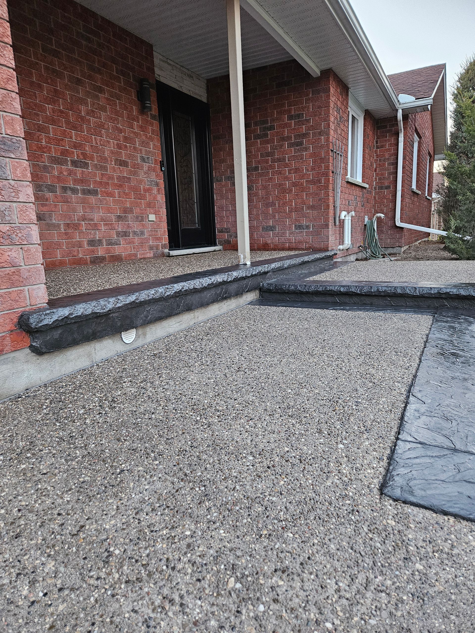A black truck is parked in the driveway of a house.