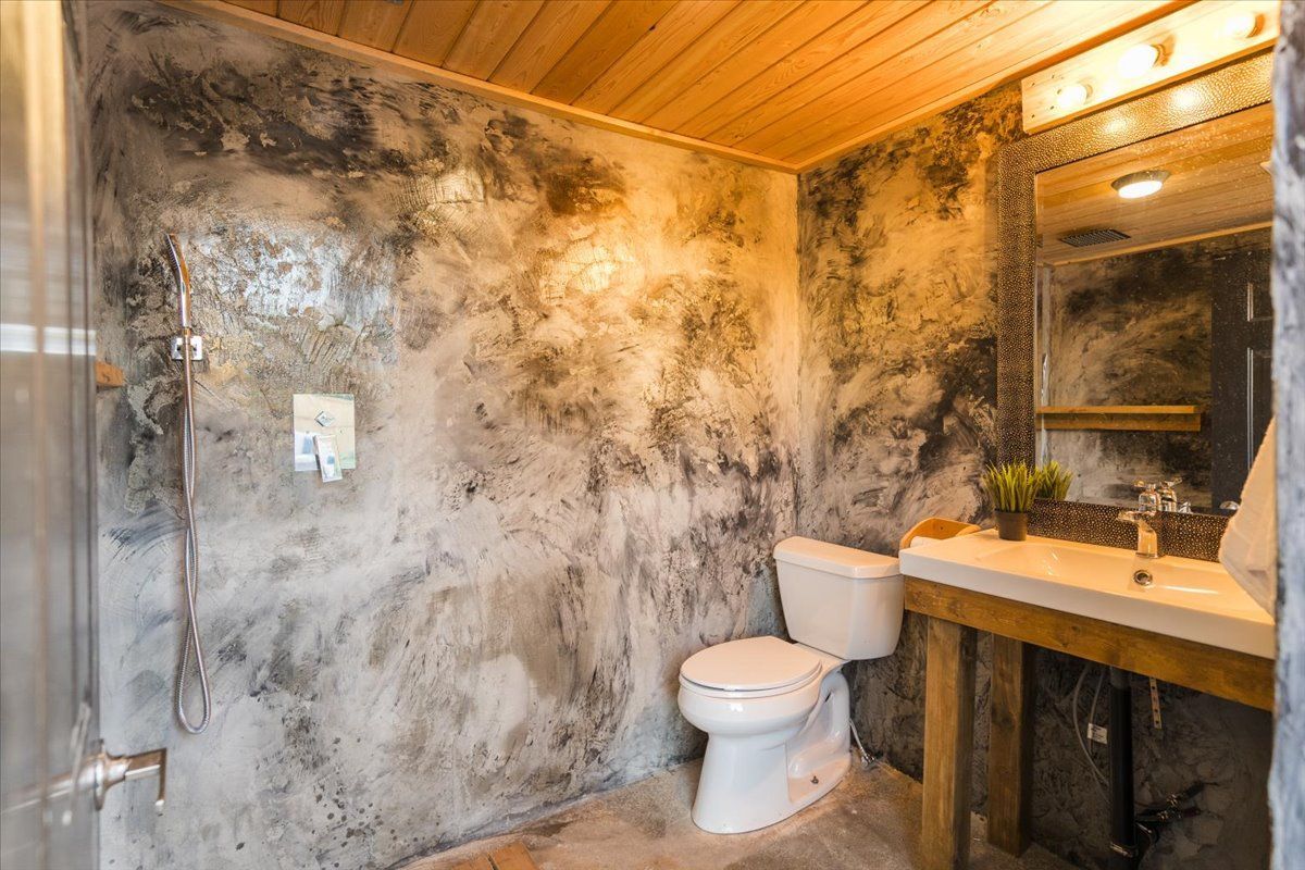 A bathroom with a toilet , sink and shower.