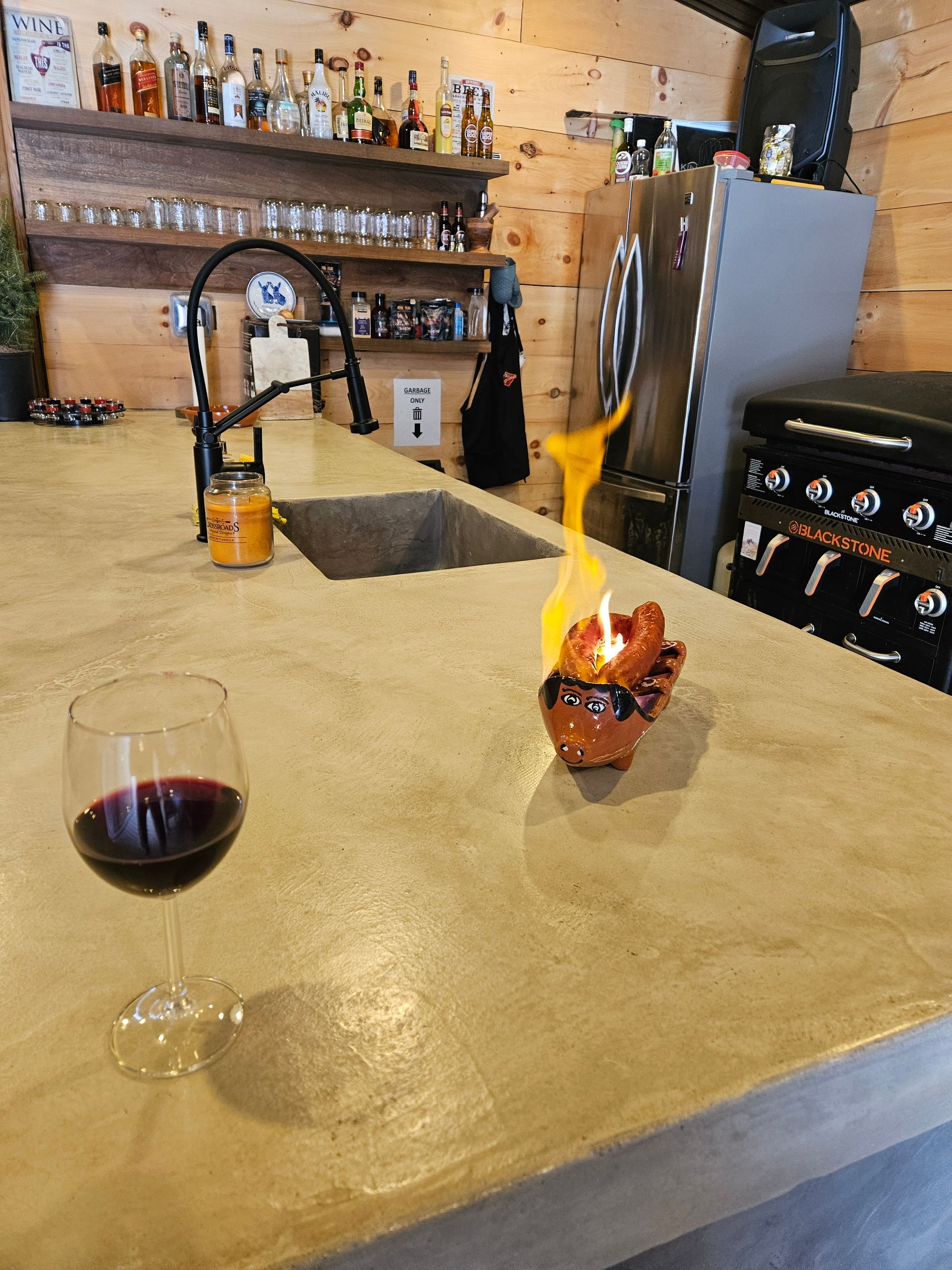 A kitchen counter with a glass of wine and a candle on it