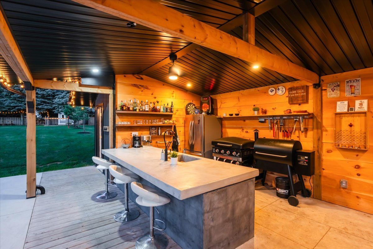 A kitchen with a large island and stools and a grill.