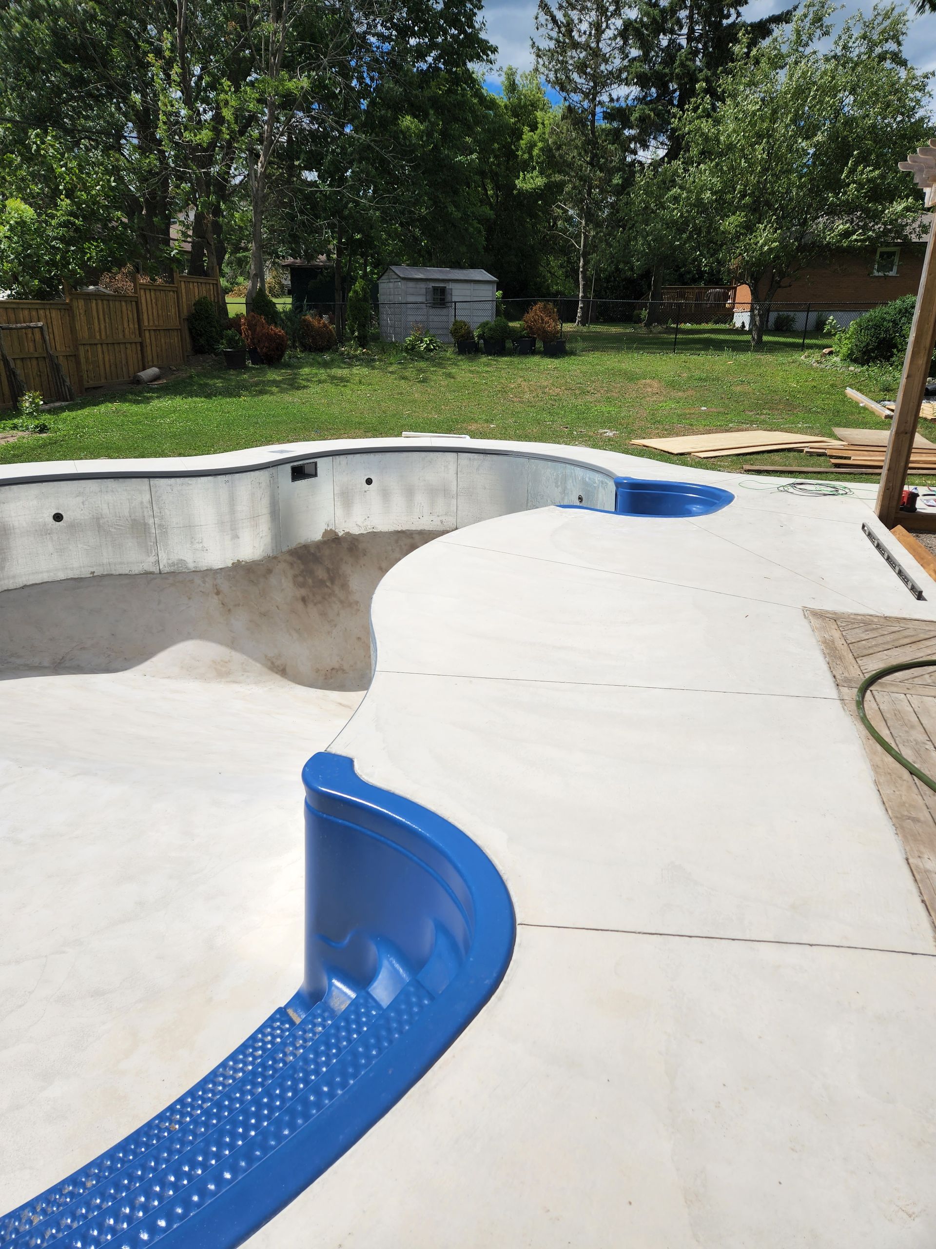 There is a large swimming pool in the backyard of a house.