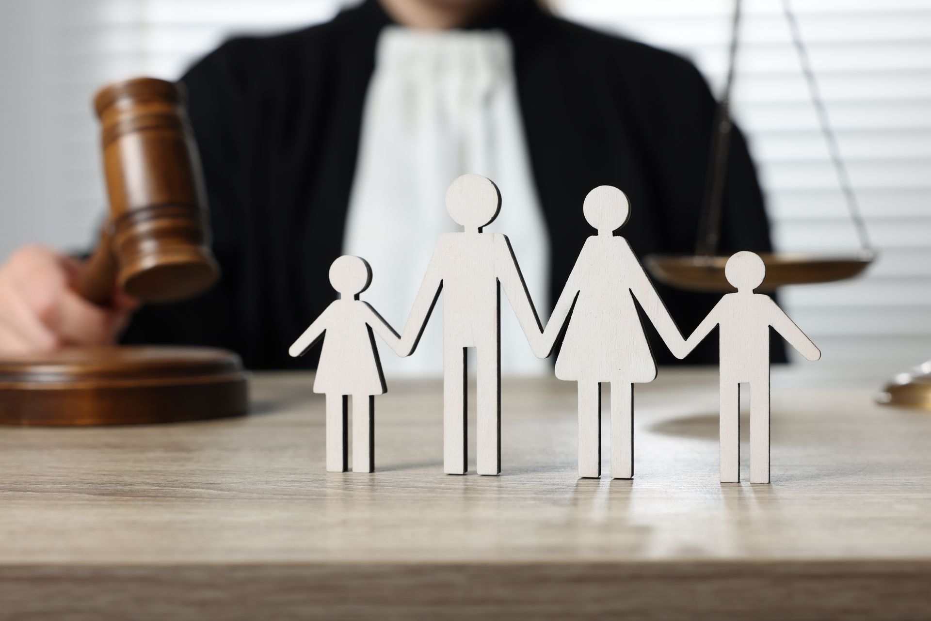 Paper family figures in front of a judge’s gavel, symbolizing family law or custody case