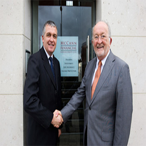 Two men shaking hands outside a building with 