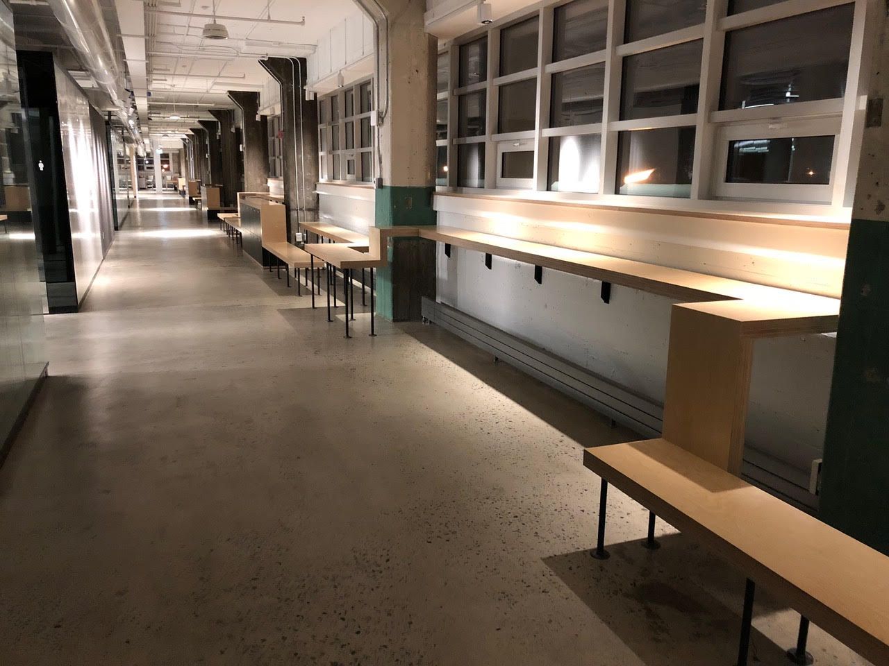 Couloir intérieur vide avec de longs bancs et des fenêtres sur le côté droit