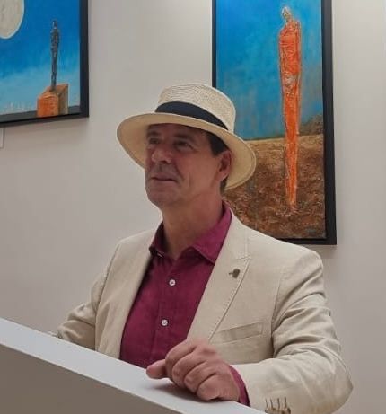 Irish artist Anthony Carey standing beside at an exhibition opening